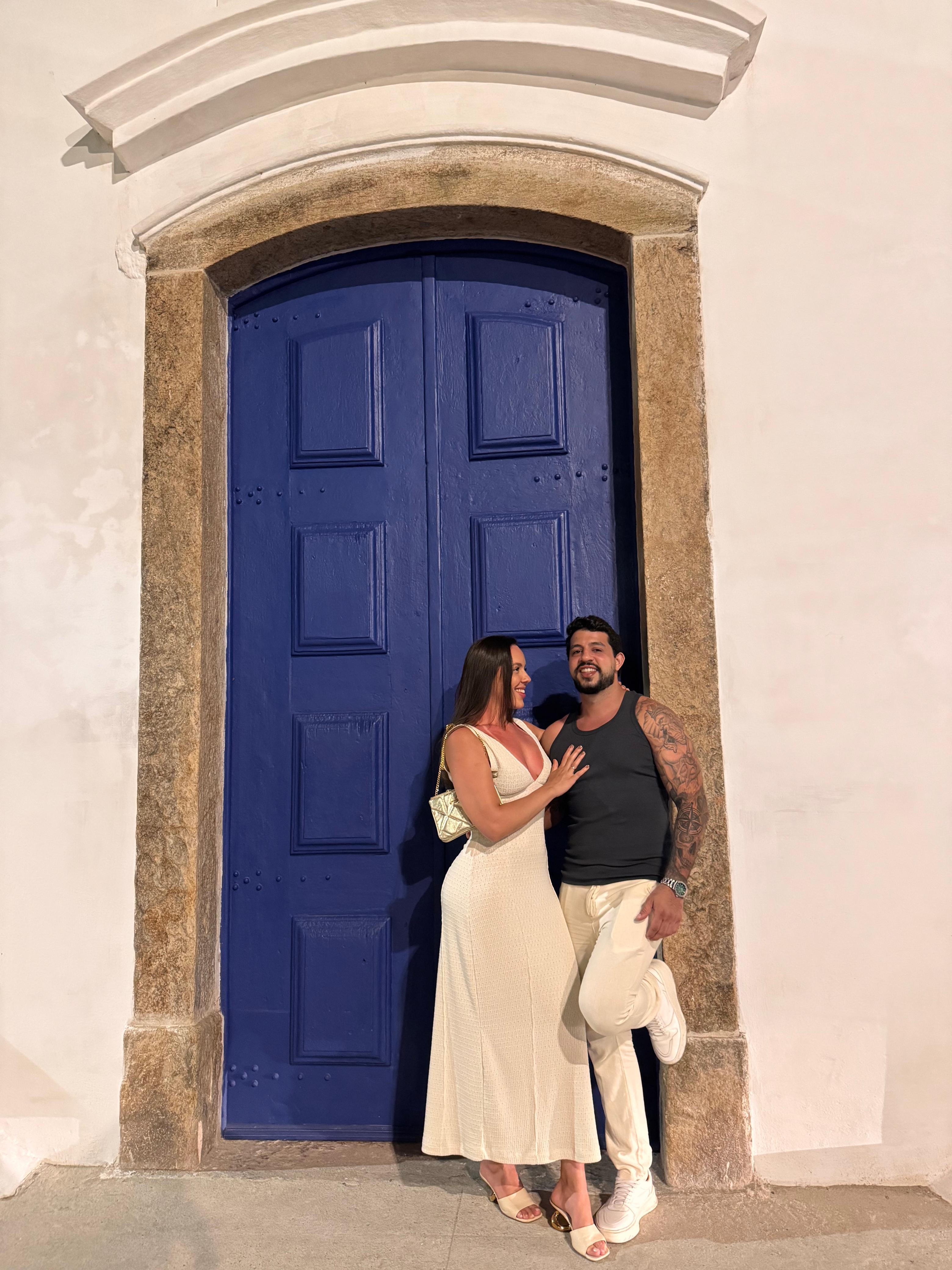 Thalyta e Maurício em frente à porta azul da igreja
