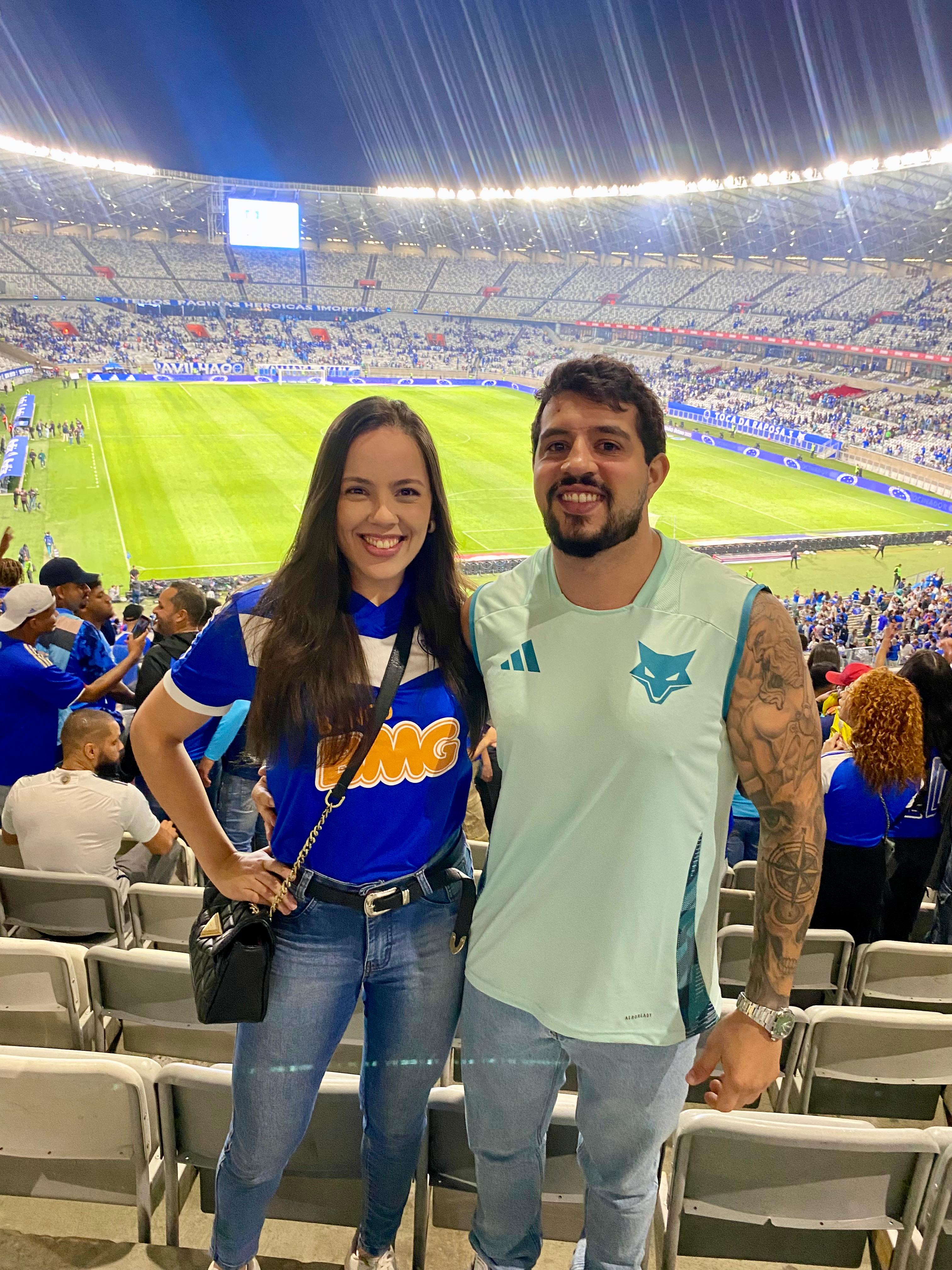 Thalyta e Maurício em um estádio de futebol